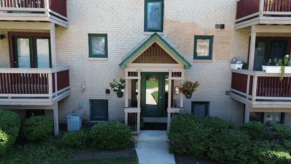 Brick entry with green door | Tycos Roofing And Siding Inc Front brick entry with green door, small gable and hanging flower baskets.