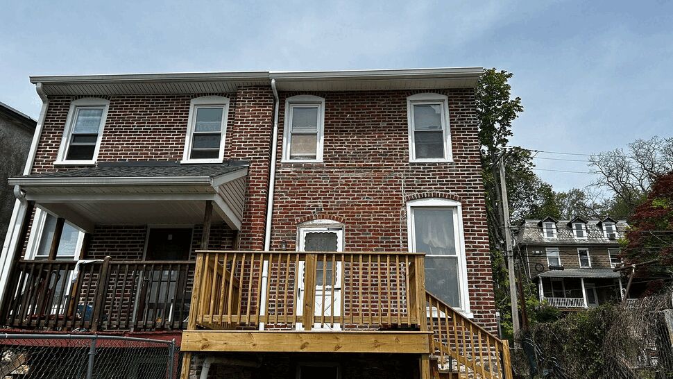 Brick home with a newly built wooden deck and stairs.