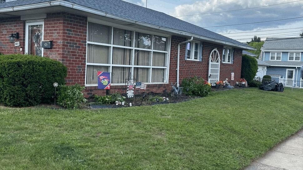 Brick ranch home with large front windows and lawn.