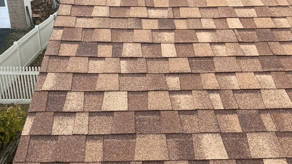 Close-up of brown asphalt roof shingles on a residential roof