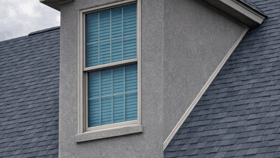 Dormer Window and Roof Detail | Tycos Roofing And Siding Inc Dormer window set into a dark shingled roof with stucco siding.