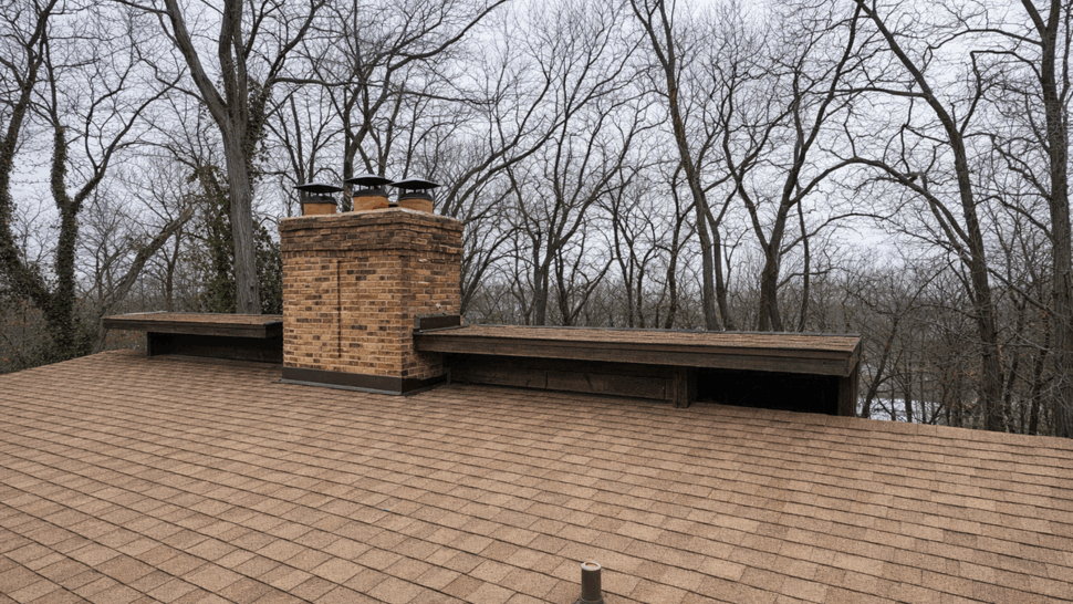 Brown shingle roof with brick chimney and vent pipe seen from above