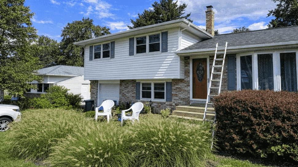 Split-level Roof with Ladder | Tycos Roofing And Siding Inc Split-level house front with ladder on roof and green lawn