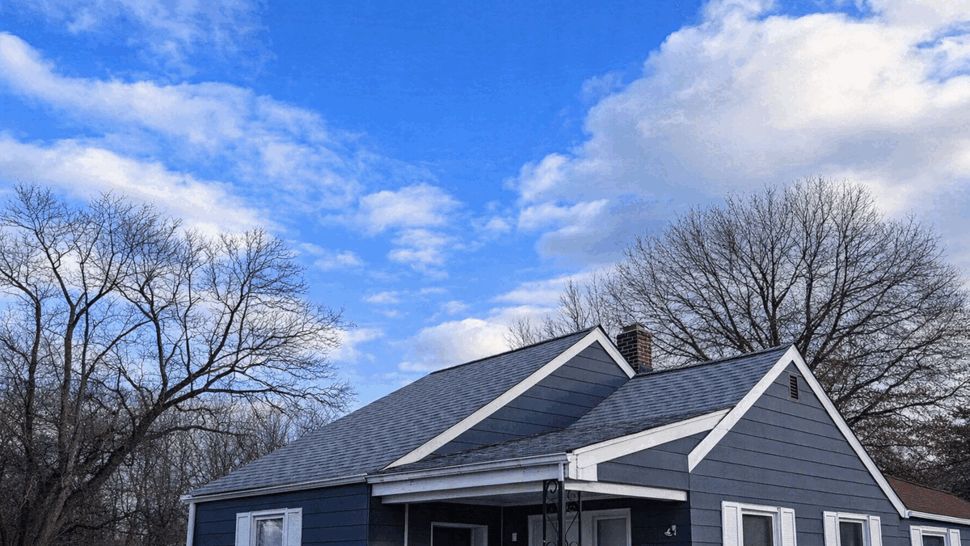 Front Home Roof Renovation | Tycos Roofing And Siding Inc Front view of a blue home with multiple gables and a shingle roof.