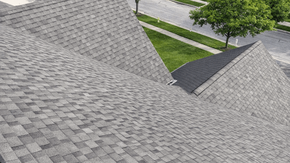 Close-up of asphalt shingle field and ridge intersections on a residential roof