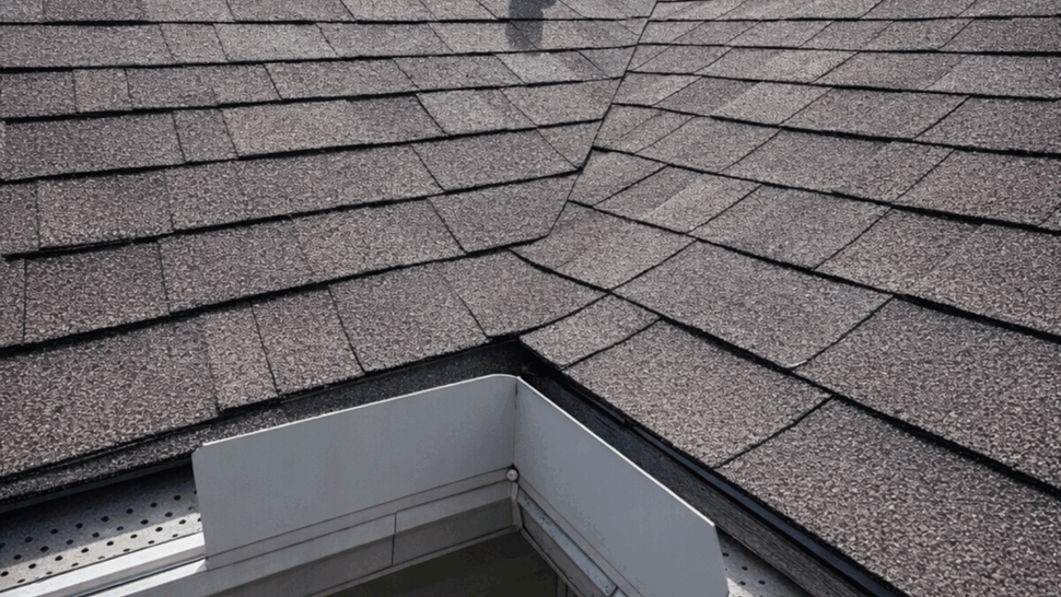 Close-up of roof valley with flashing, vent pipe, and gutter interface