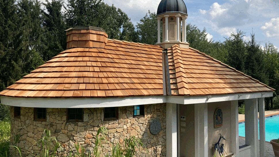 Poolside stone poolhouse with new cedar shingle roof and cupola