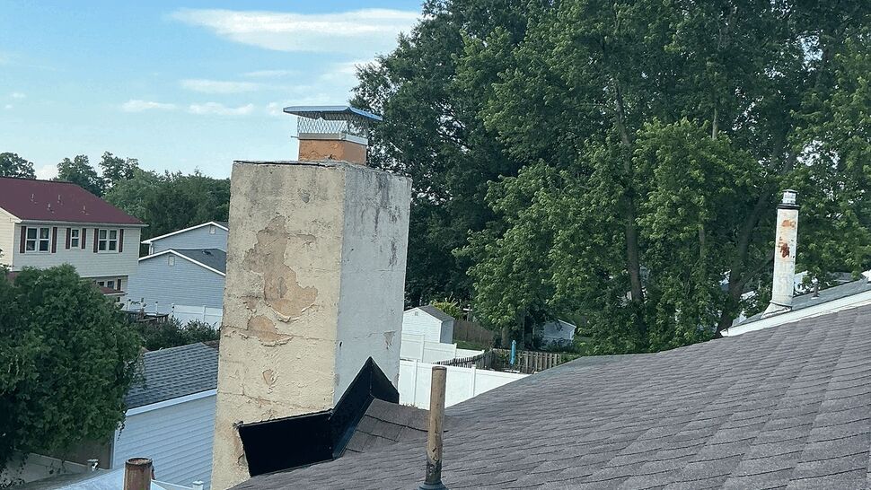 Chimney flashing and storm damage inspection | Tycos Roofing And Siding Inc Chimney with weathered masonry next to roof vents on a shingled roof.