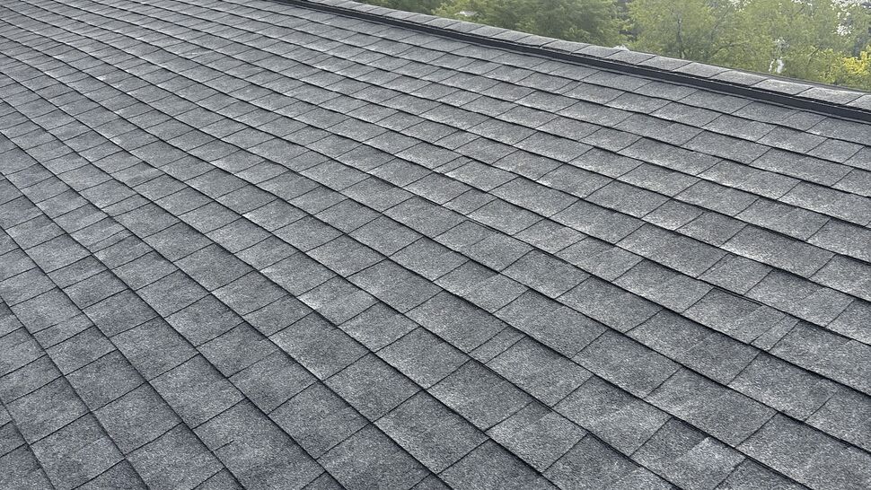Close-up view of overlapping gray asphalt roof shingles