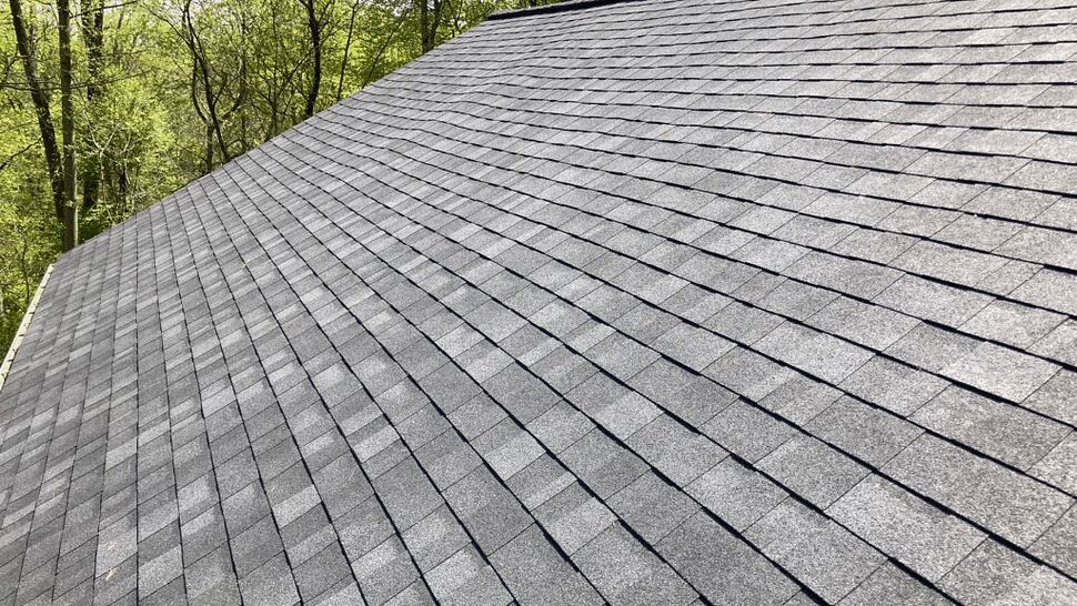 Close-up view of gray asphalt shingles on a steep roof slope