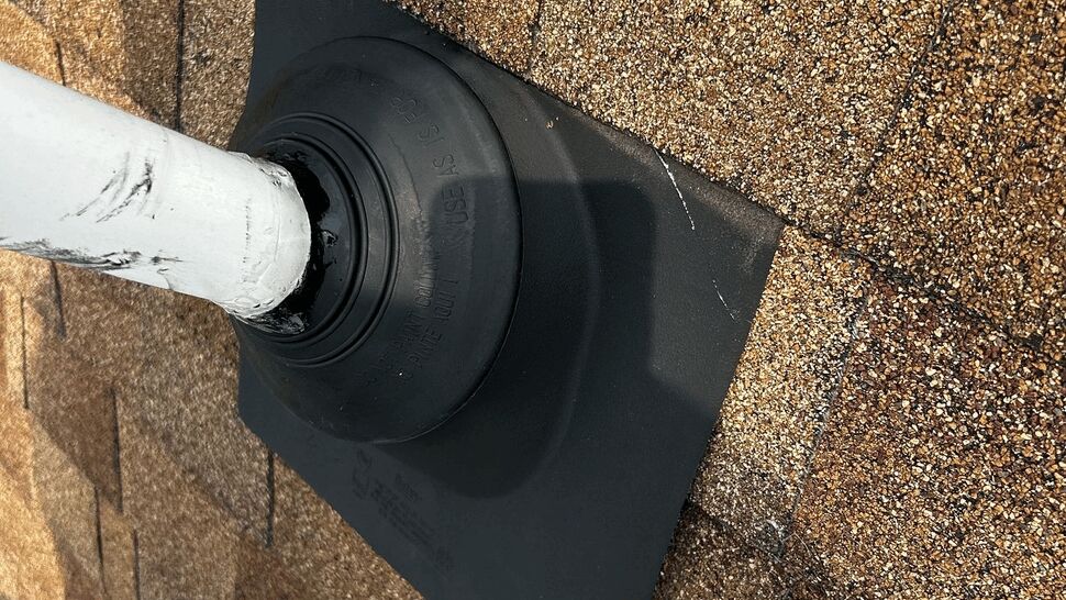 Close-up of pipe boot flashing sealed to asphalt shingles