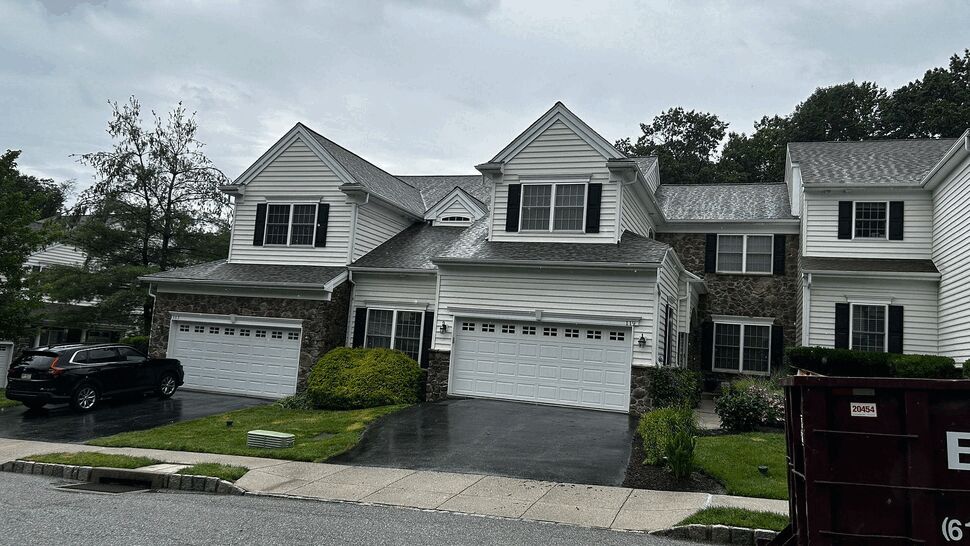 Front view of a two-story townhouse with white siding and double garages