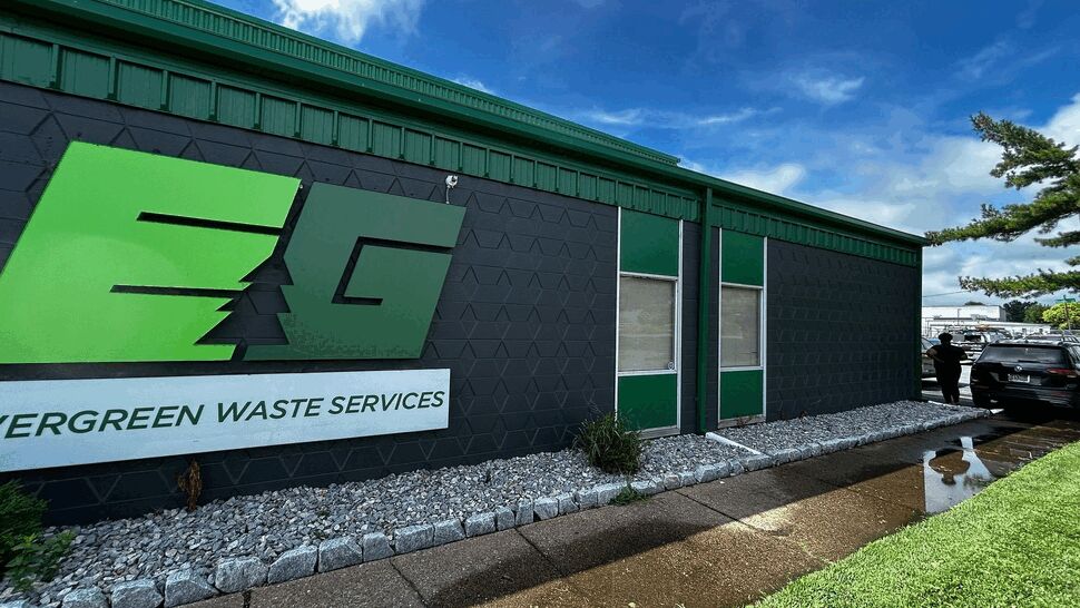 Green Trim Commercial Siding | Tycos Roofing And Siding Inc Exterior of a green-trim commercial building with dark siding and gravel landscaping