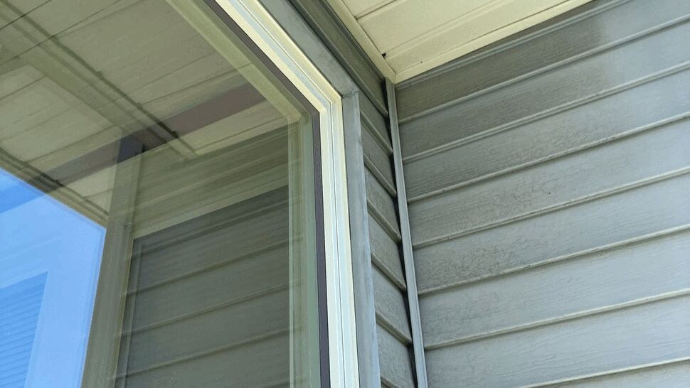 Corner Window and Siding Detail | Tycos Roofing And Siding Inc Close-up of corner window frame and surrounding vinyl siding