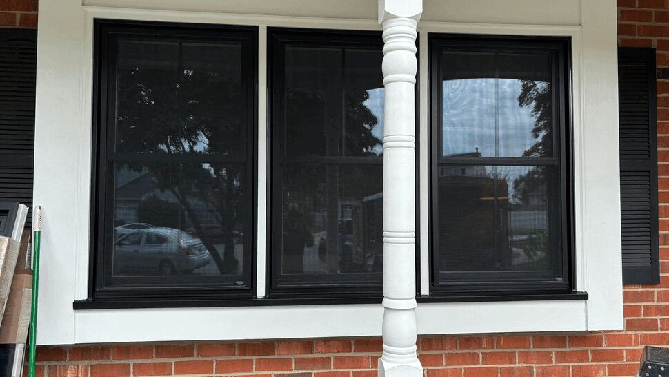 Covered Porch Window Installation | Tycos Roofing And Siding Inc Three black-framed windows installed beneath a covered porch.