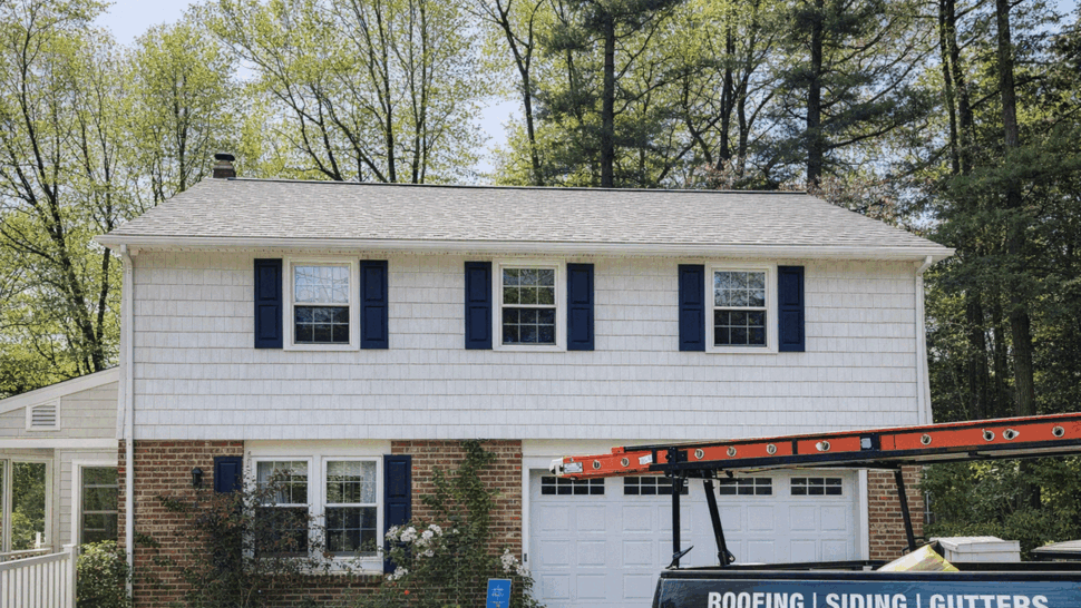 Front view of a two-story house with company truck and new roof visible