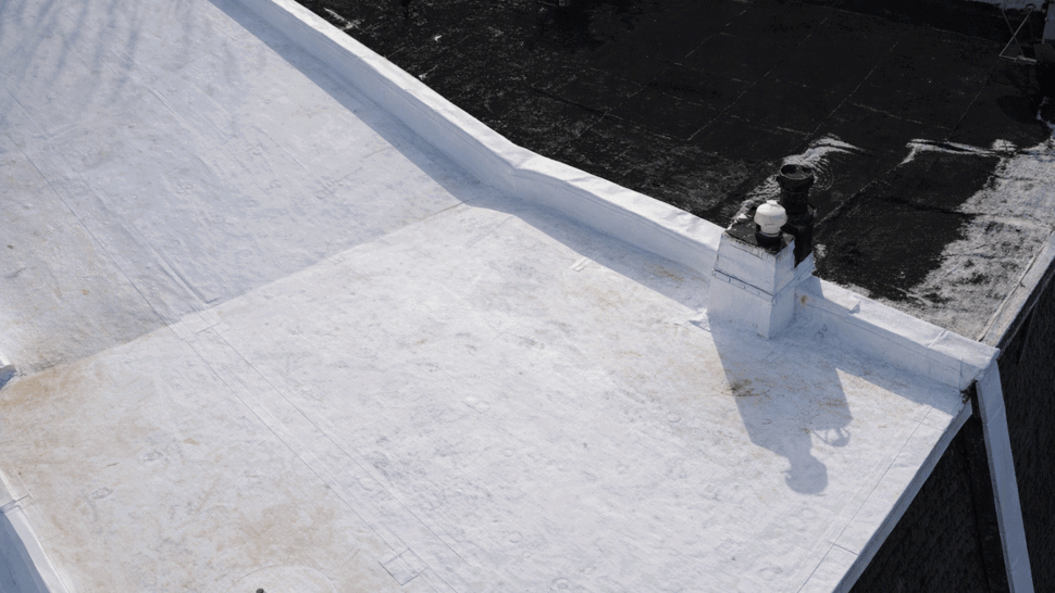 Close aerial detail of a roof seam and vent flashing on white membrane