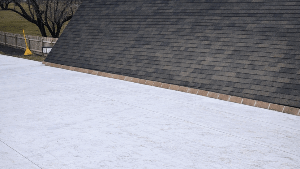 White TPO flat roof installed next to a steep shingled roof.