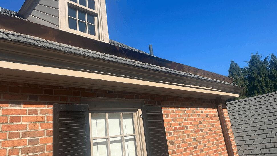 Close-up of dormer with copper flashing and gutter along the roofline