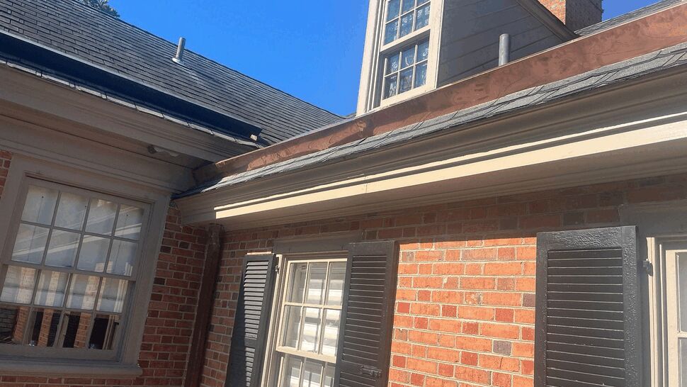 Wide view of dormer flashing and roof edge above shuttered window