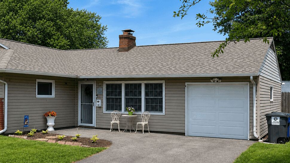 Driveway view of home's front entry, garage and windows under the roofline