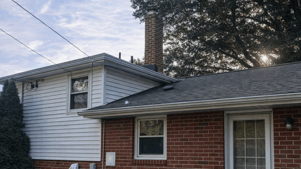 Home Roofing and Gutters | Tycos Roofing And Siding Inc Rear exterior of a brick home with roof, siding, windows, and gutters