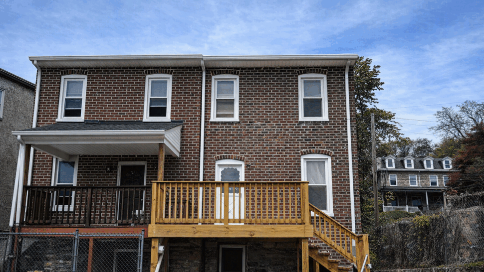 New Wooden Deck on Brick Home | Tycos Roofing And Siding Inc Brick home with a newly built wooden deck and stairs.