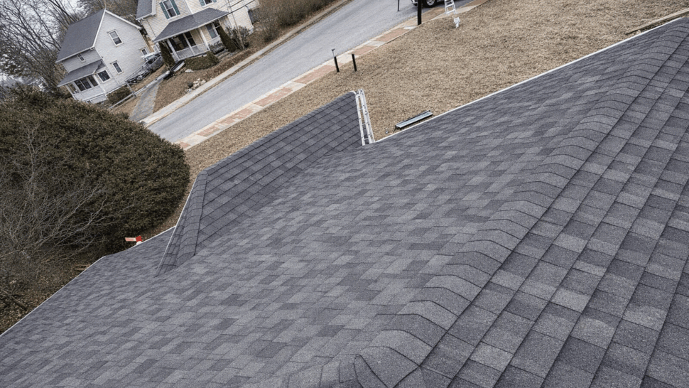 Asphalt Shingles and Ridge Vent | Tycos Roofing And Siding Inc High-angle view of dark asphalt shingles and ridge vent on a pitched roof.
