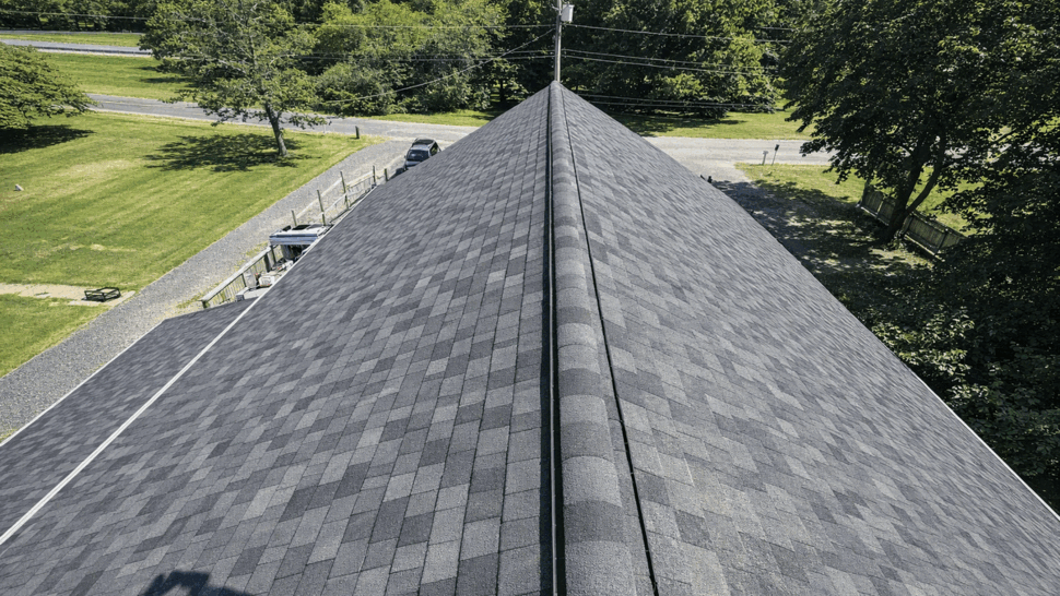 Aerial shingle ridge installation | Tycos Roofing And Siding Inc Aerial view of a newly shingled roof ridge with ridge vent running along the peak