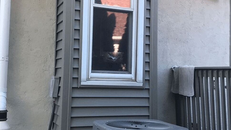 Close-up of a window bay above an outdoor HVAC unit
