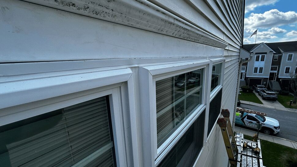 Gutter and Window Exterior Repair | Tycos Roofing And Siding Inc Exterior row of windows with gutter above and scaffold below