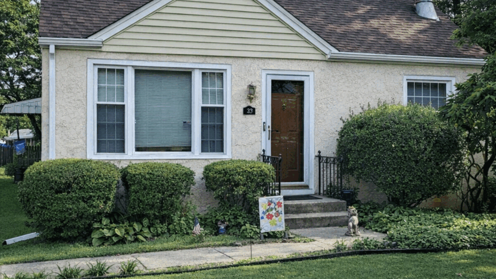 Front Cottage with Brown Roof | Tycos Roofing And Siding Inc Small stucco cottage with brown shingle roof and front lawn