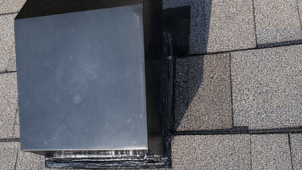 Close-up of metal roof vent flashing installed on asphalt shingles