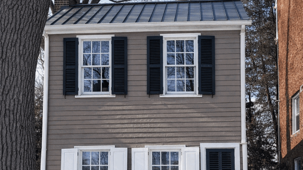 Historic House Windows | Tycos Roofing And Siding Inc Historic home with white windows, dark shutters, and a standing seam metal roof