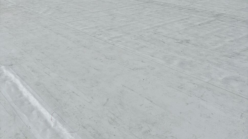 Flat roof surface with visible seams and rooftop HVAC unit