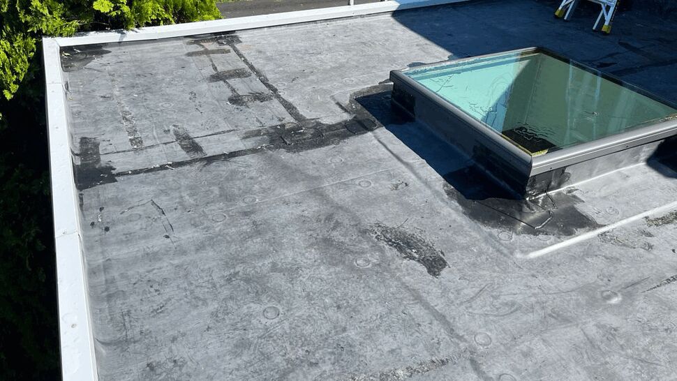 Close detail of skylight flashing and repairs on flat roof