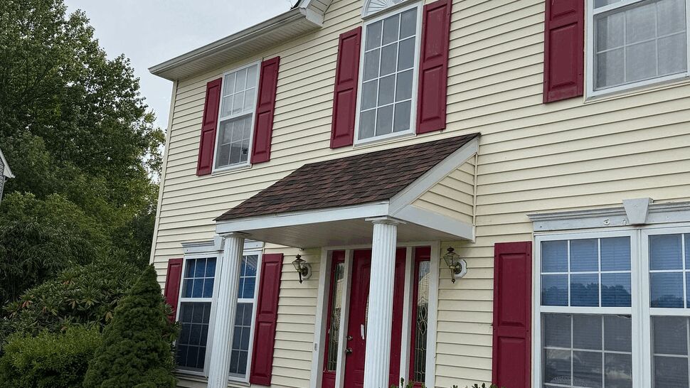 Front Siding and Windows | Tycos Roofing And Siding Inc Front exterior of a cream-sided home with red shutters, windows, and entry porch