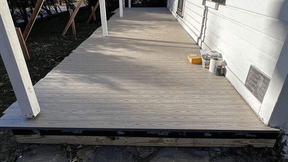 Front porch deck under construction with temporary supports and decking materials