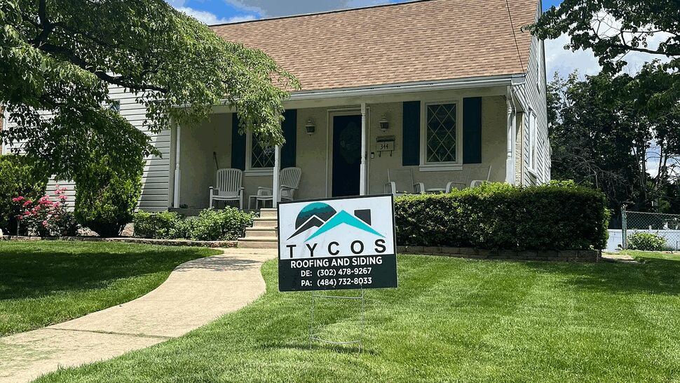 Front lawn with Tycos sign and a newly shingled brown roof