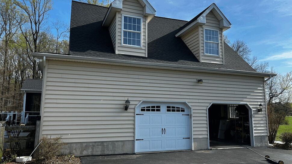 Two-car garage with white carriage-style doors and dormer windows above