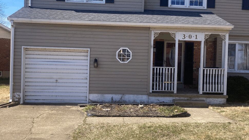 Close-up of garage, front porch, and entry door with decorative octagon window