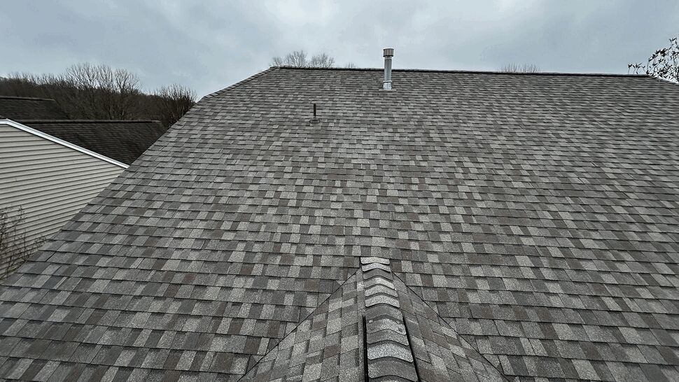 Top-down view of a gray asphalt shingle roof with vents