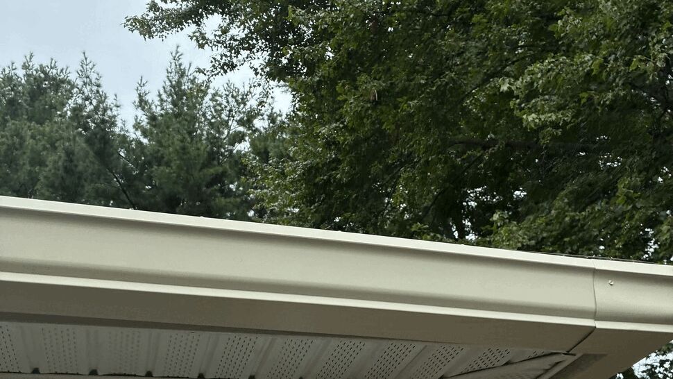 Gutter corner with 3x4 downspout | Tycos Roofing And Siding Inc Close-up of gutter corner and curved 3x4 downspout at building eave
