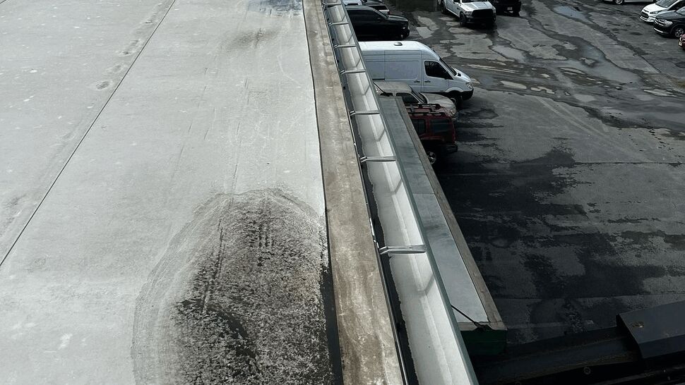 Flat Roof Gutter Inspection | Tycos Roofing And Siding Inc Flat roof edge with metal gutter and visible water stains and ponding on the roof membrane