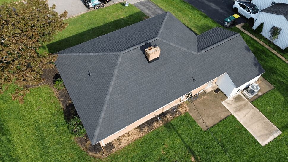 Aerial Hip Roof Installation | Tycos Roofing And Siding Inc Top-down aerial of a newly shingled hip roof on a brick home.