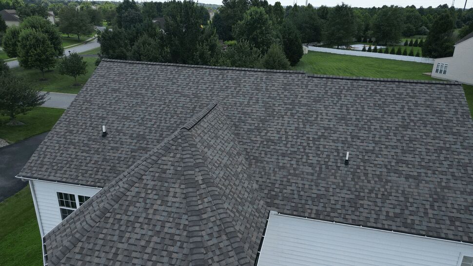 Hip roof shingle detail | Tycos Roofing And Siding Inc Top-down view of a hip roof with asphalt shingles and roof vents.