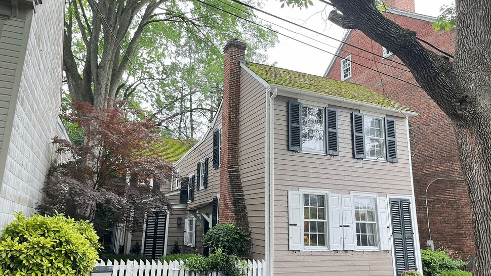 Historic Home Siding | Tycos Roofing And Siding Inc Historic gray-sided home with black shutters, white trim, and garden landscaping