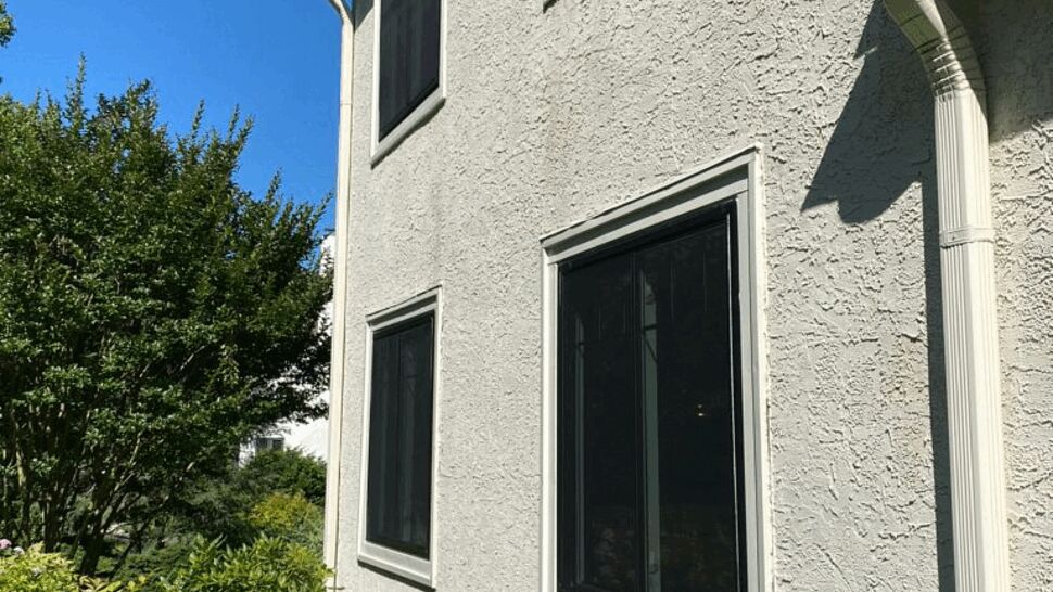 Side of house showing gutter, downspout and two-story windows.