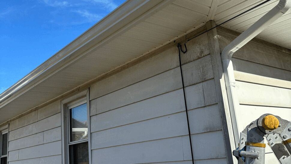 Vinyl siding with gutter, downspout and ladder at the corner