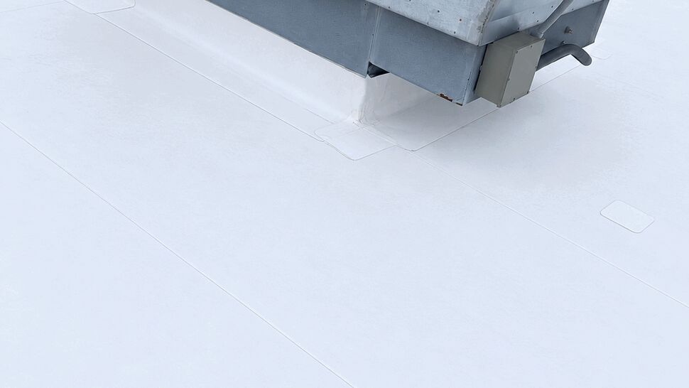 HVAC curb flashing detail | Tycos Roofing And Siding Inc Close-up of HVAC curb flashing and sealed white roof membrane.